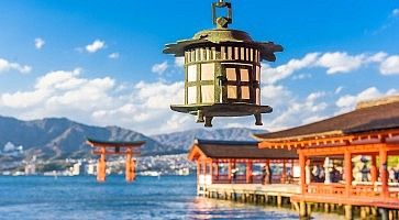 Lanterna al santuario Itsukushima e in lontananza il torii di Miyajima.
