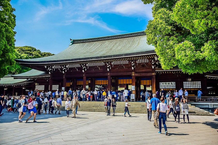 Visitatori al Santuario Meiji a Tokyo in una giornata soleggiata.
