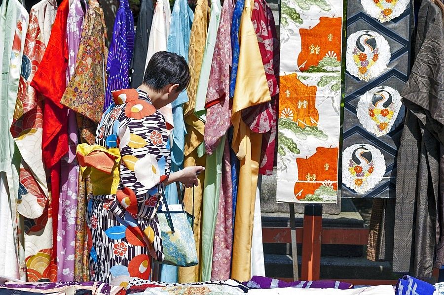 Una persona osserva kimono colorati esposti a Tokyo.