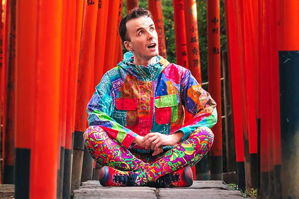 Marco Togni, con vestiti colorati, in Giappone tra i torii di un santuario