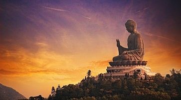 Il Buddha di Po Lin al tramonto, con un bellissimo cielo arancione e viola.