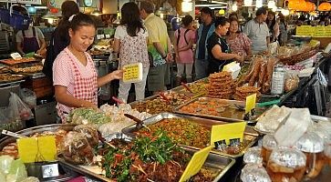 Una signora vende cibo al Chatuchak Market di Bangkok.