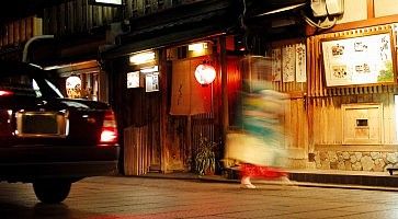 Una geisha si affretta ad andare al lavoro, ad Hanamikoji Dori a Kyoto.