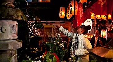 Una ragazza compie un rito al tempio Hozenji.