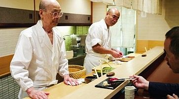 Jiro, la leggenda del sushi, mentre cucina dietro al bancone nel suo ristorante.