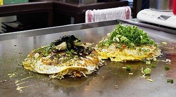 Okonomiyaki sulla piastra ad Okonomimura.