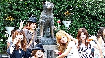 Ragazze giapponesi in posa davanti alla statua di Hachiko a Shibuya.